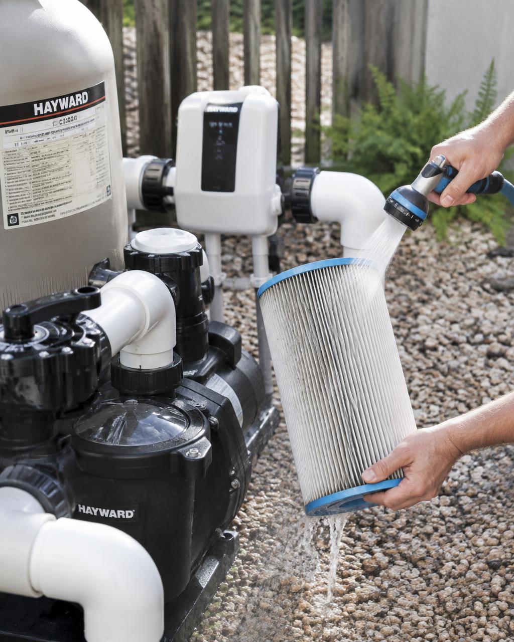 Pool filter cartridge being rinsed beside pump and salt cell equipment